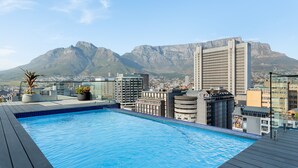A rooftop pool with a cityscape and mountains in the background. - Stylish Minimalist: The Tokyo|Mountain and City View (Cape Town)