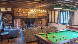 A cozy room with a pool table, a fireplace, and a sofa. - Beautiful 10 Bed Oak beamed Country House (Tibenham)