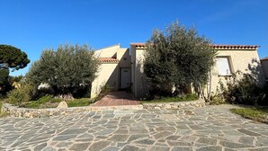 A stone-paved entrance to a building with a tiled roof and a door. - Villa de 220 m2 Avec Piscine et vue mer à 5min des Plus Belles Plages de Balagne (L'ile-Rousse)
