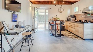 Eine moderne Küche mit Holzbalken, einem Essbereich mit Barhocker und einem großen Fenster.