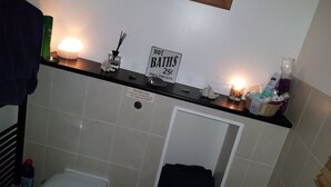 Une salle de bain avec une pancarte indiquant que des bains chauds sont disponibles pour 25 cents, ainsi que des articles de toilette et un porte-serviettes.