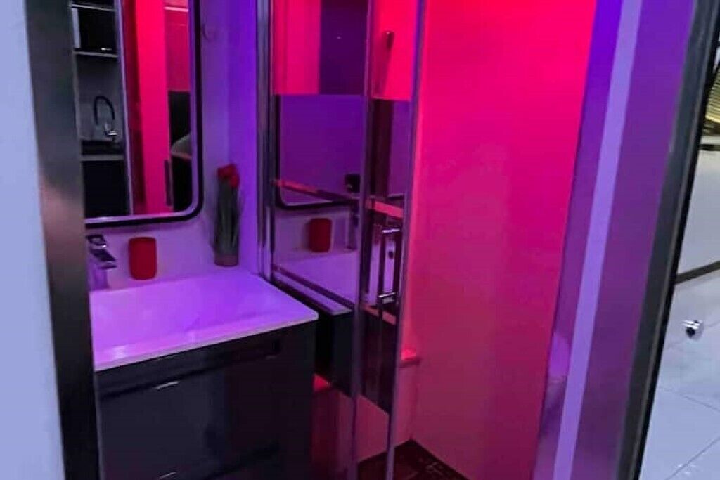 Ein kleines Badezimmer mit Waschbecken, Spiegel und Ablage.