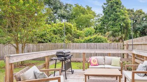 A wooden deck with outdoor furniture, a grill, and a wooden fence. - Cozy Cottage, Deck + Yard, Near Downtown & 10 min to Parris Island (Beaufort)