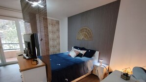Ein modernes Schlafzimmer mit Bett, Nachttisch und Schreibtisch.
