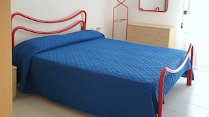 A bedroom with a bed, a dresser, a mirror, and a window with curtains. - Nice and Cozy Flat 100m From the Beach - Beahost (San Michele al Tagliamento)