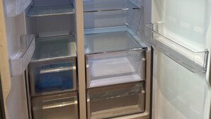 An interior view of a modern refrigerator with multiple shelves and compartments. - 3 minutes from the lake, with a large terrace and garden (Leggiuno)