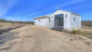 A single-story mobile home with a front porch and a small entryway. - K Loma Vista With Hill Country Views (Center Point)
