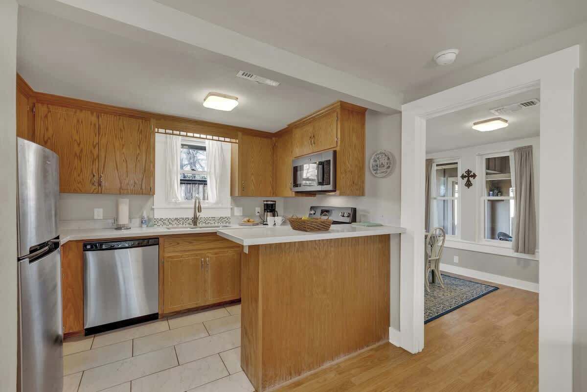 A modern kitchen with wooden cabinets, stainless steel appliances, and a central island.