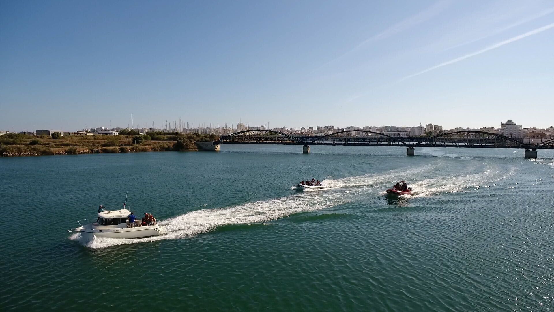 A river with boats and a bridge in the background.
