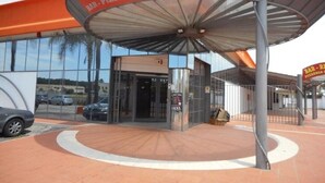Un restaurant doté d’une entrée couverte et d’une enseigne indiquant qu’il sert des pizzas et des paninis.