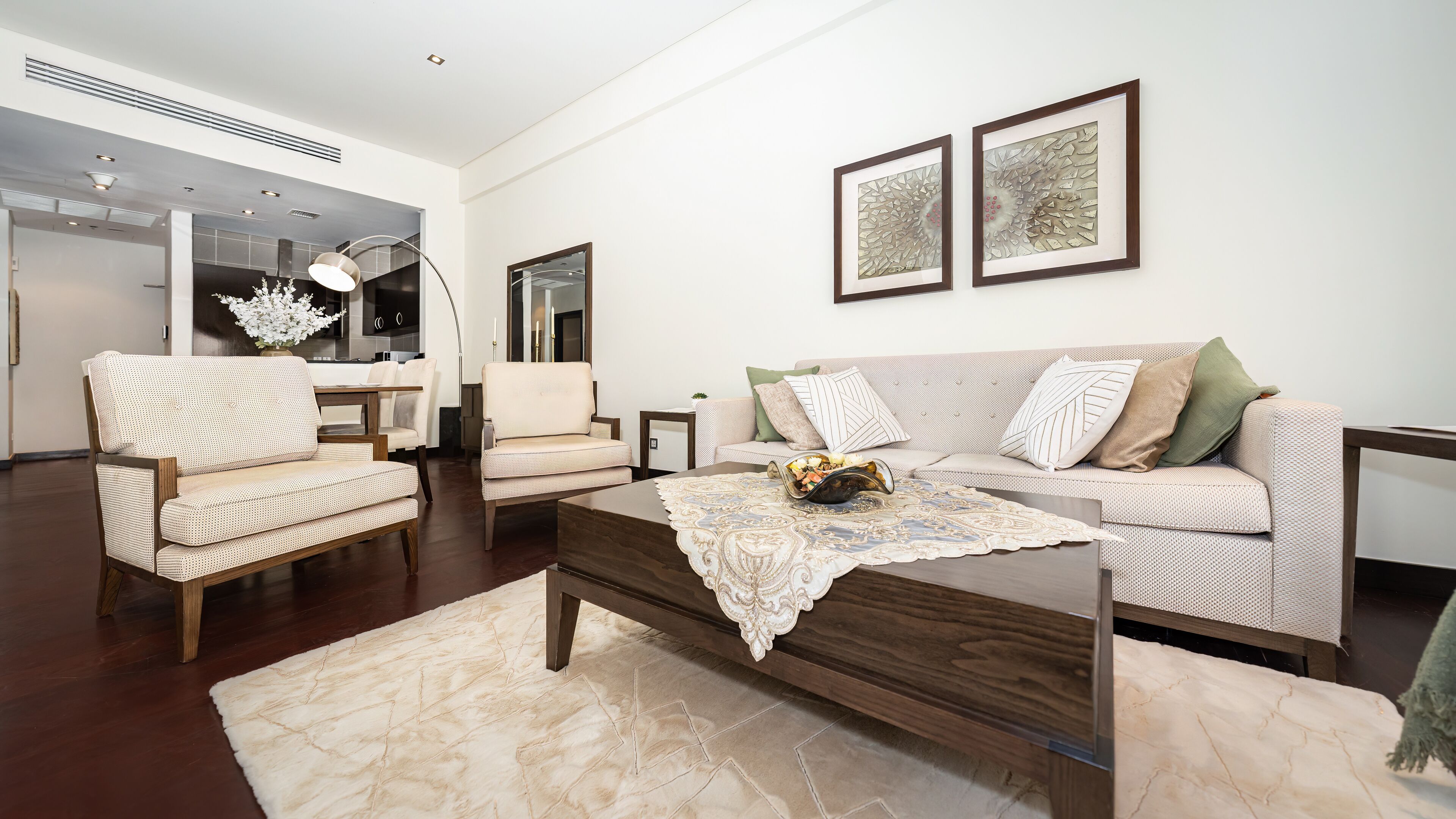 A modern living room with a sofa, armchairs, a coffee table, and artwork on the wall.