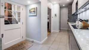 A modern kitchen with a marble countertop and stainless steel appliances. - Stunning 3 bed flat in the heart of Chelsea (London)
