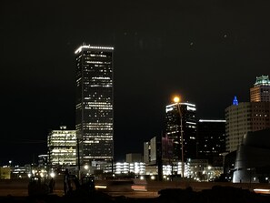 Une vue nocturne d’une ville, avec des gratte-ciel illuminés et du matériel de construction.