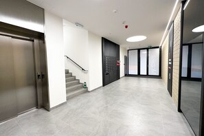 Stairs lead to upper floors, with secure double doors and convenient storage lockers.