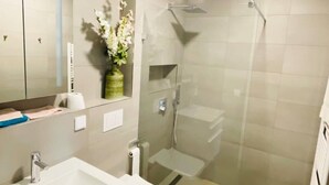 A modern bathroom with a sink, toilet, and glass-enclosed shower. - New Studio in Belair with balcony (Luxembourg City)