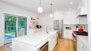 Una cocina moderna con armarios blancos, electrodomésticos de acero inoxidable y una isla grande.