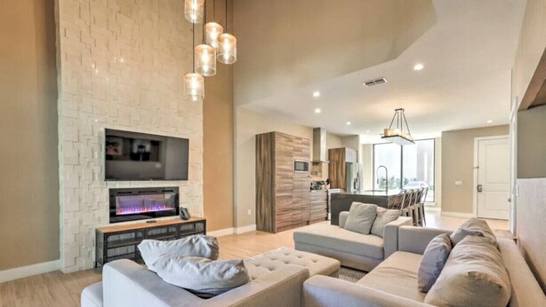 A modern living room with a fireplace, a TV, and a large sectional sofa.