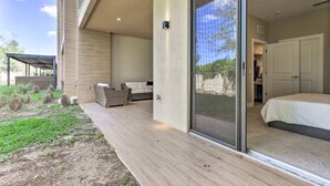 A modern bedroom with a large sliding glass door leading to a balcony.