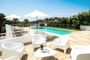 Relax by the pool surrounded by lush views and shaded seating areas.