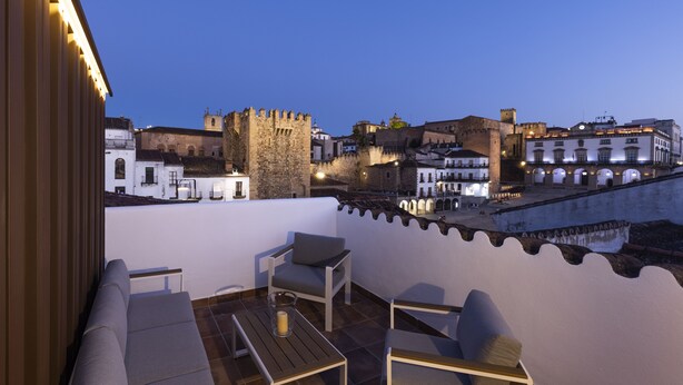 Une terrasse offrant une vue sur des bâtiments historiques et un château.