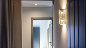 Un couloir doté d’un sol à motifs, d’un plafond en bois et d’une porte fermée à clé.