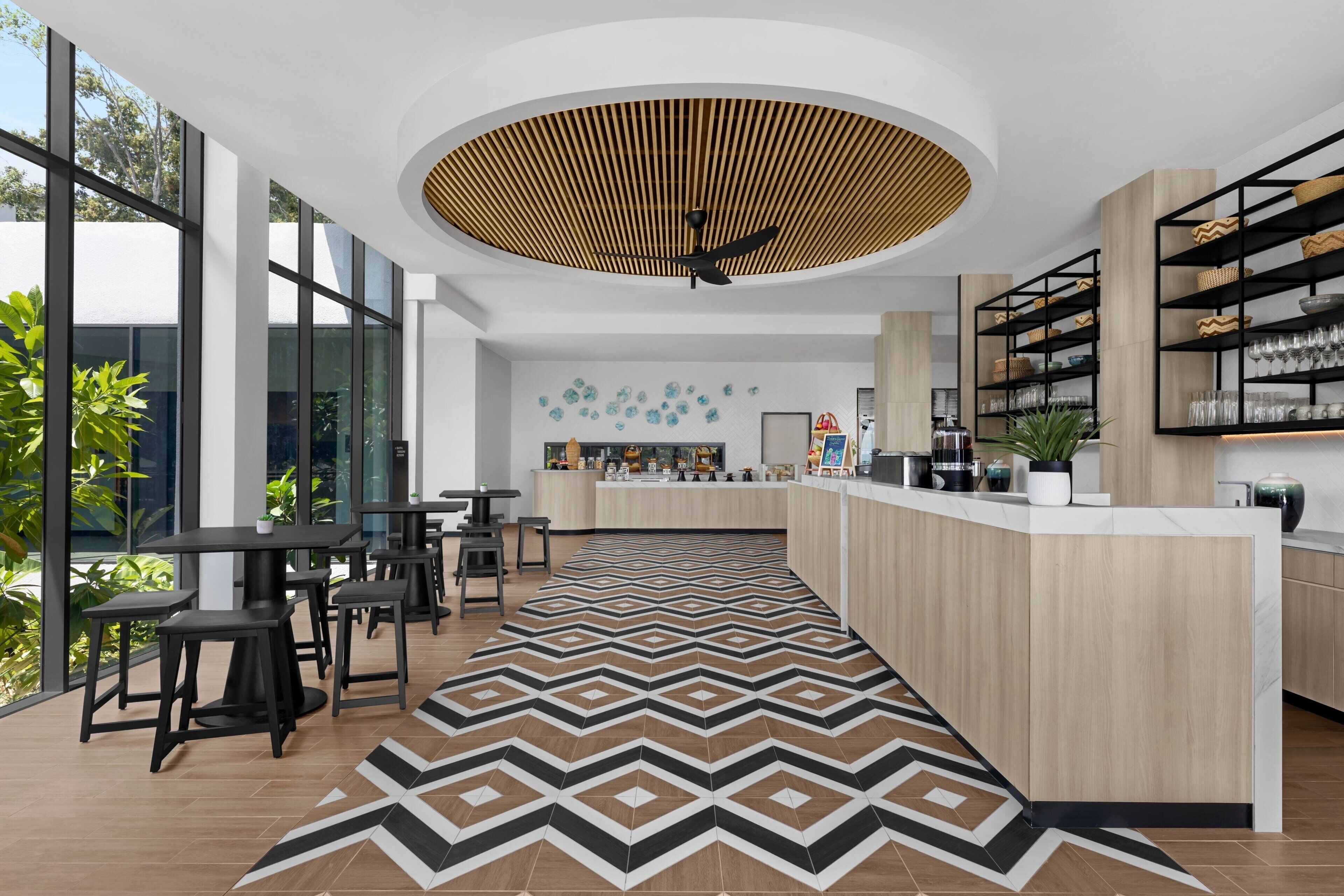 A modern kitchen with a central island, bar area, and seating.