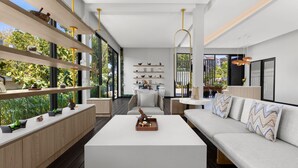 Ein modernes Wohnzimmer mit einem weißen Sofa, einem Couchtisch und Regalen mit Dekoration.