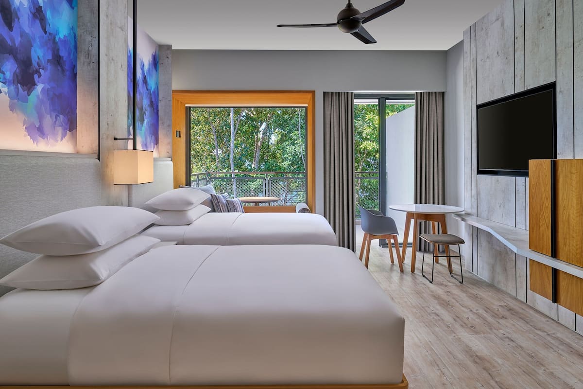 A modern hotel room with a large bed, a desk, and a TV.