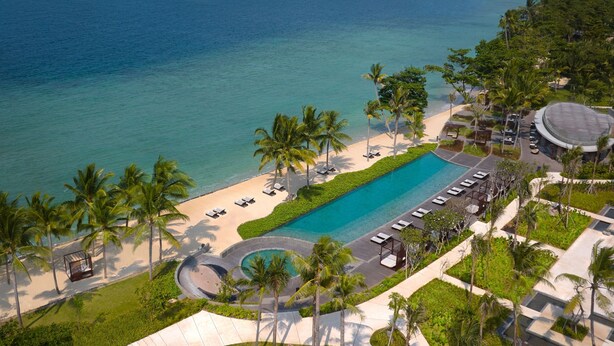 A resort with a large pool, palm trees, and a beach. - Lampung Marriott Resort & Spa (Bandar Lampung)