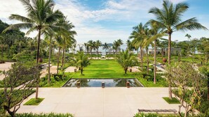 A resort with a central lawn, palm trees, and a swimming pool. - Lampung Marriott Resort & Spa (Bandar Lampung)