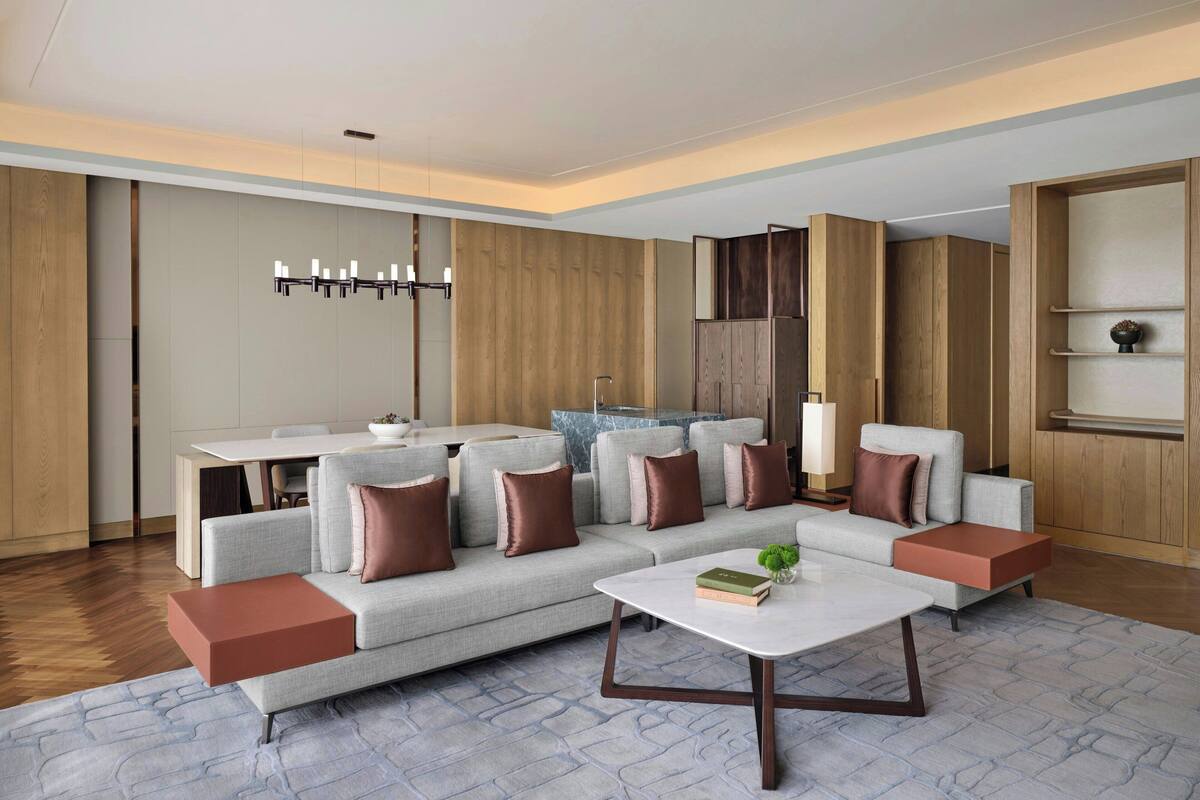 Een moderne woonkamer met een hoekbank, een salontafel en een eethoek met een tafel en stoelen.