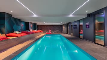 Relax by the rectangular pool surrounded by comfortable benches and geometric-patterned walls.