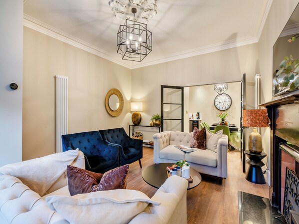 A living room with a sofa, armchair, coffee table, and a fireplace.