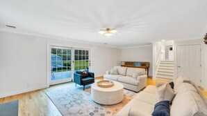 A spacious living room with a large window, a round coffee table, and two sofas.