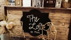 A sign with the text "The Lost on Main" in a rustic setting. - The Loft on Main (Belmont)