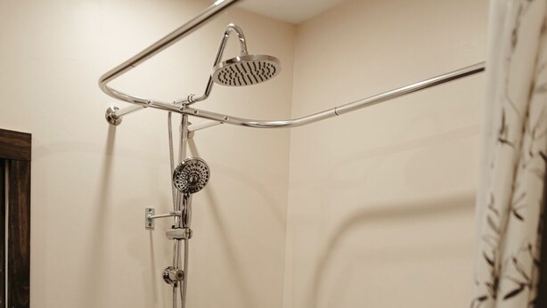 A bathroom with a freestanding bathtub, a showerhead, and a handheld shower attachment.