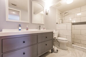 Un baño moderno con tocador, inodoro y ducha.