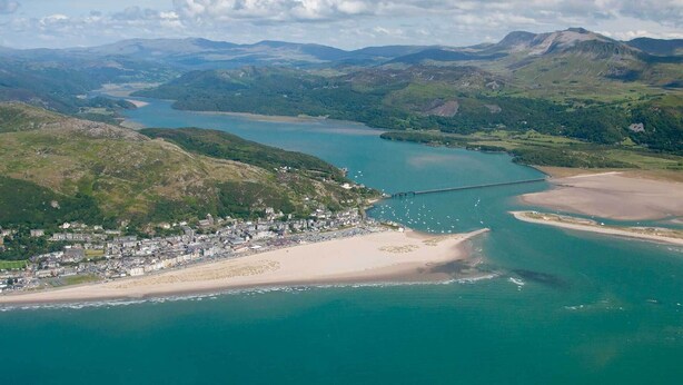 An aerial view of a coastal town with a beach, a bridge, and a bay. - Beach Haven (Hafan y Traeth)  (Barmouth)