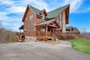 A large log cabin with a stone foundation, multiple decks, and a covered porch. - Morven by Avantstay Secluded w/ Mountain Views! (Sevierville)
