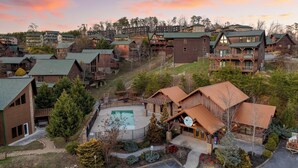 Een resort met meerdere houten bungalows, een centraal gelegen zwembad en een bord waarop staat 'Happy Host'.