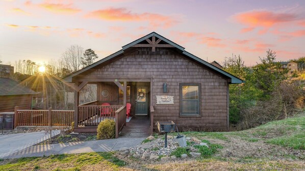 A wooden cabin with a porch, a front door, and a sign that reads "Family Tradition."
