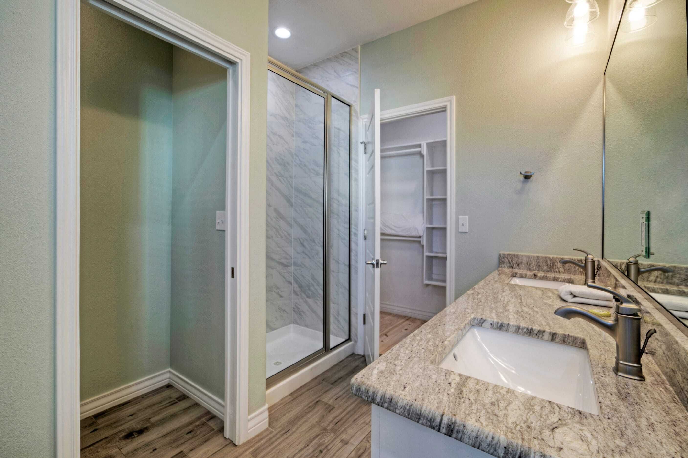 A bathroom with a shower, a sink, and a mirror.