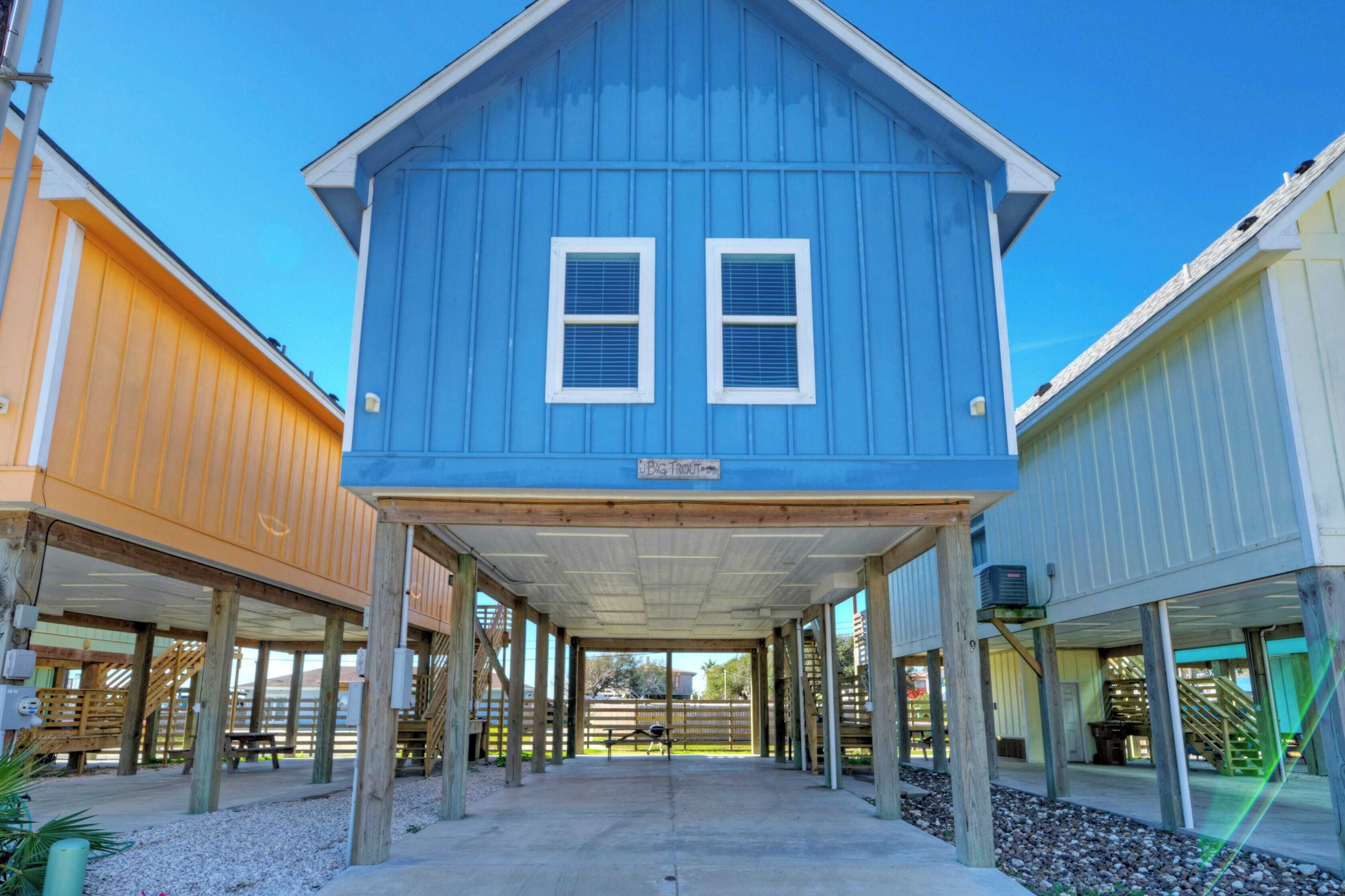 A blue building with two windows and a covered walkway.