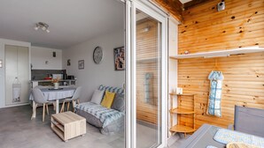 Un salon confortable avec un canapé, une table à manger et une cuisine en arrière-plan.