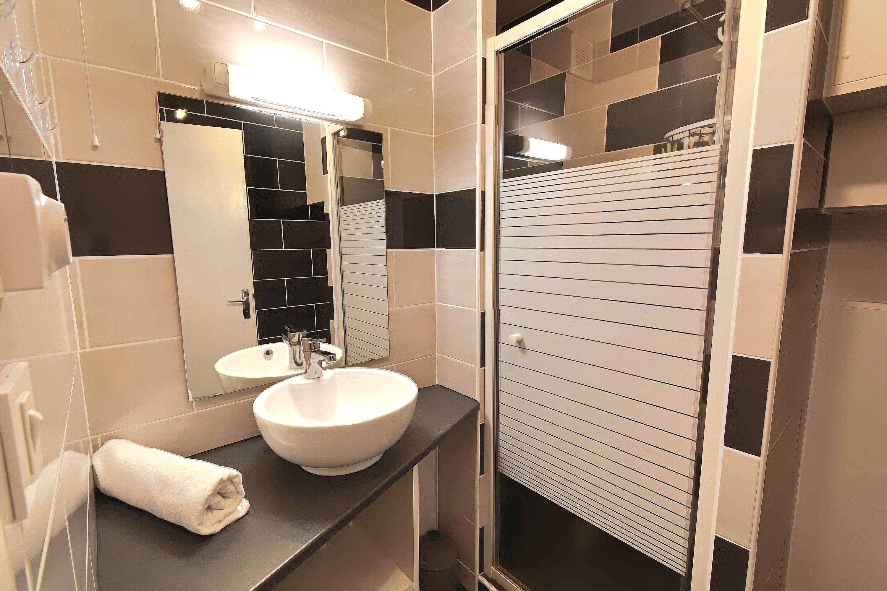 A bathroom with a white sink, a mirror, and a towel on the counter.