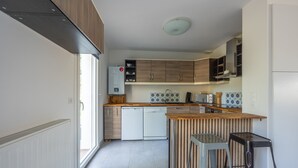 Una cocina moderna con armarios de madera, una isla central y un lavavajillas integrado.