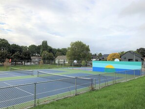 An outdoor tennis court with a fence, a basketball court, and a mural. - Centrally located East Vancouver Studio
(In-suite laundry)
 (Vancouver)