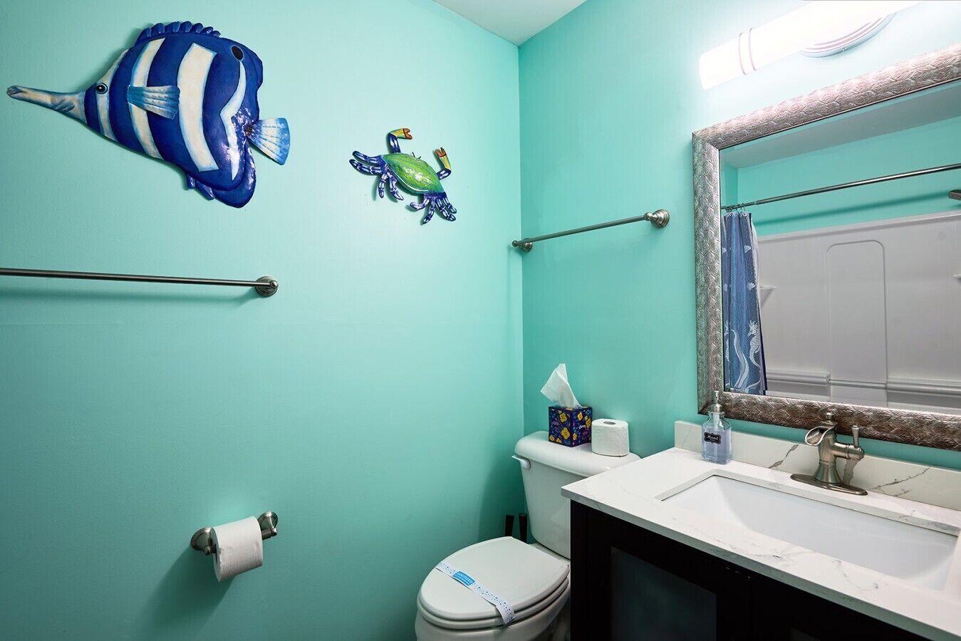Une salle de bain équipée de toilettes, d’un lavabo et d’un porte-serviettes.