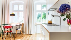 Una cocina moderna con encimera de madera, un lavamanos y un ventanal con cortinas.