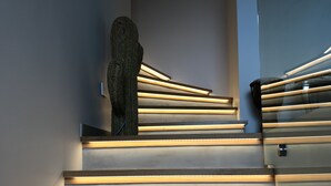 Una escalera de madera con escalones iluminados, que conduce a una plataforma.